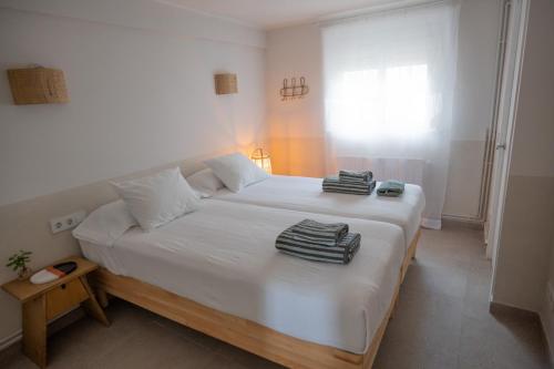 a bedroom with a large white bed with towels on it at Casa Belladona in Calonge