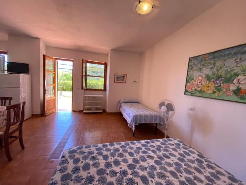 a bedroom with a bed and a table and a window at Parco delle Ginestre in Portoferraio