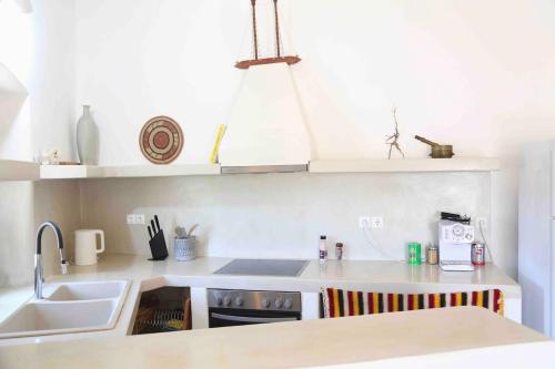 a kitchen with a sink and a counter top at Rouga - bright terrace studio in Aroniadika