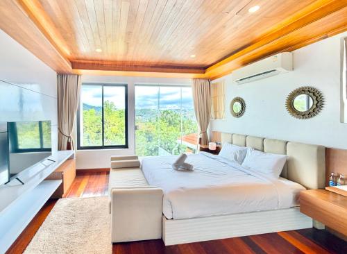 a bedroom with a large bed and a large window at Anara Pool Villa 3 Bedrooms in Nathon Bay
