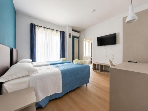 a bedroom with a bed and a flat screen tv at 7 LAKES Aparthotel in Burolo