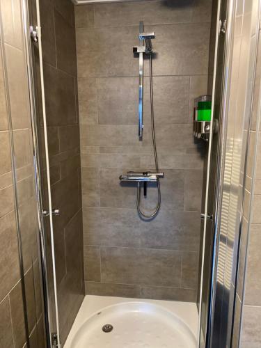 a bathroom with a shower with a tub at Bed en Breakfast Romee in Epe