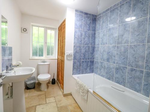 a bathroom with a tub and a toilet and a sink at Mill Lodge in Brisley