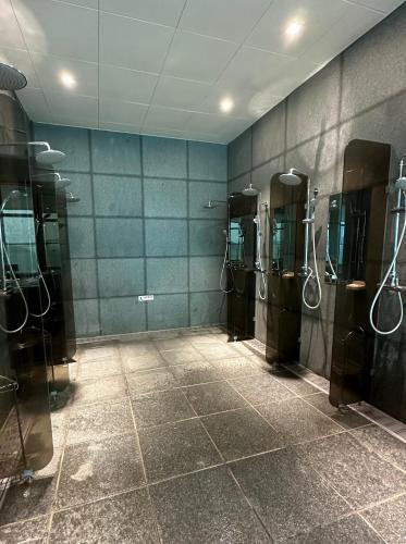 a bathroom with a row of stalls with showers at 광안비치스테이&Spa in Kwangan-dong