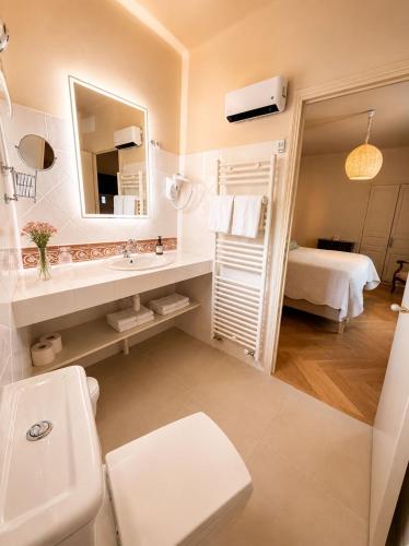 a bathroom with a sink and a toilet and a mirror at Le Relais Notre Dame in Quinson