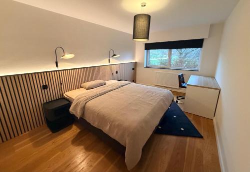 a bedroom with a bed and a desk and a window at Villa Winbomont in Malmedy