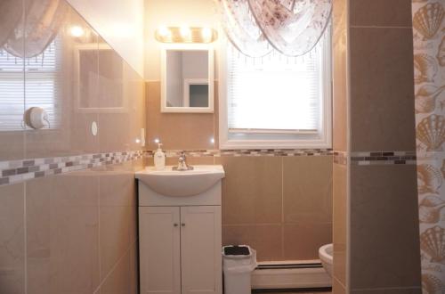a bathroom with a sink and a toilet and a window at West New York room 15 in West New York