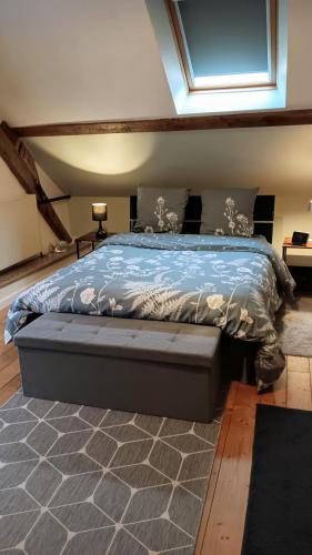 a bedroom with a bed with a blue comforter at Au Nid Douillet in Gilocourt