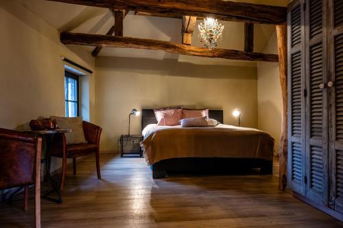 ein Schlafzimmer mit einem Bett, einem Tisch und einem Stuhl in der Unterkunft B&B Sapere in Genoelselderen