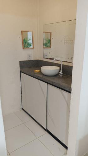 a bathroom counter with a sink and a mirror at Pousada Mel in Praia do Forte