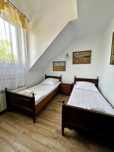 two twin beds in a room with a window at Leśna Ostoja in Górniki