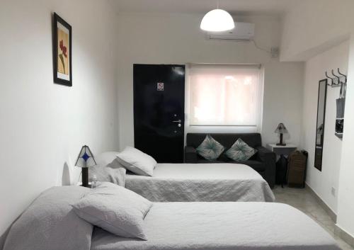 a hotel room with two beds and a couch at Moreno924 in Barraquero