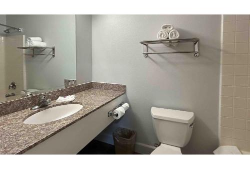 a bathroom with a sink and a toilet and a mirror at Studio 6 Suites Hesperia CA West Main Street I 15 in Hesperia