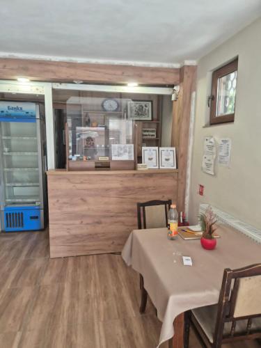 a dining room with a table and a counter at Хотел М in Asenovgrad