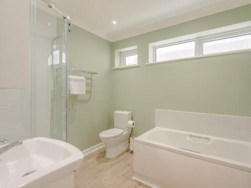 a white bathroom with a tub and a toilet at 2 Bed in Ferndown oc-78541 in Ferndown