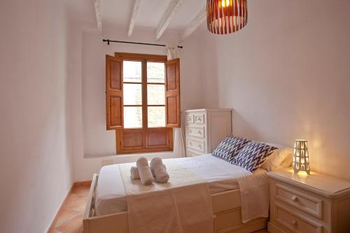 a white bedroom with a bed and a window at Ca nostra in Artá