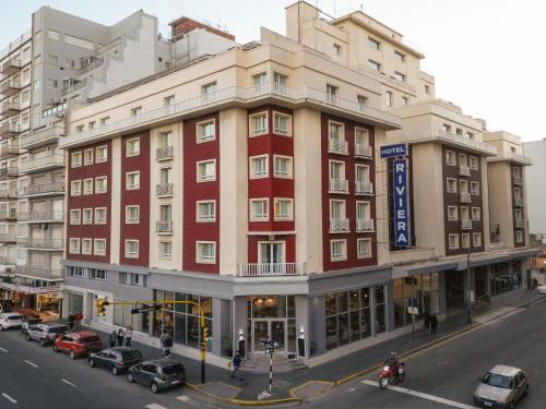 a large red building on a city street with cars parked at Hotel Riviera in Mar del Plata