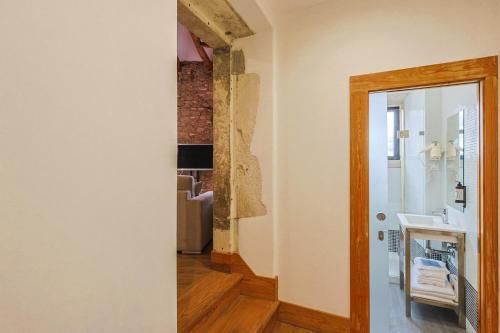 a bathroom with a sink and a mirror at Casa da Sé by PURUS in Coimbra