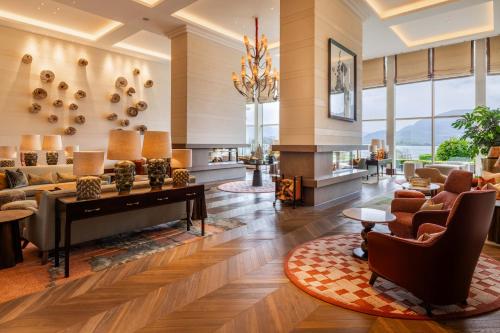 a living room with a grand piano and chairs at The Europe Hotel & Resort in Killarney