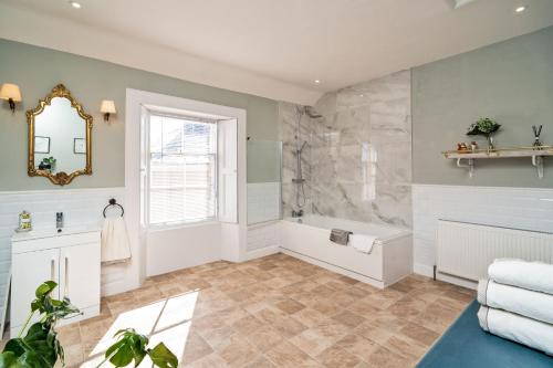 a bathroom with a shower and a tub and a sink at Kirkland in Berwick-Upon-Tweed