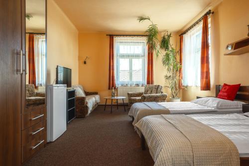 ein Schlafzimmer mit zwei Betten und ein Wohnzimmer in der Unterkunft Hotel Jaro in Mělník