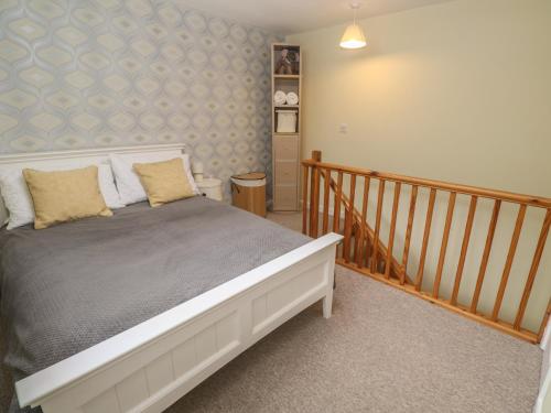 a bedroom with a bed and a stair case at Mini Mena in St Austell