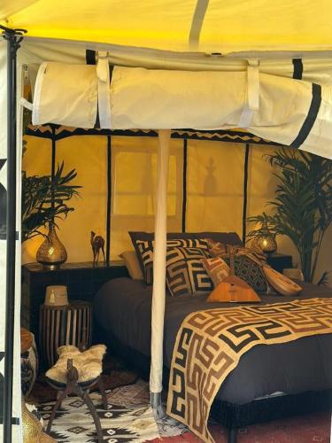 a bedroom with a bed with a yellow canopy at Lodge SAHARA in Arques