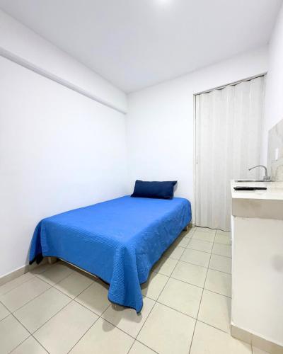 a bedroom with a blue bed in a white room at Hotel Posada Centro Atlacomulco Cuarto Barra in Atlacomulco de Fabela