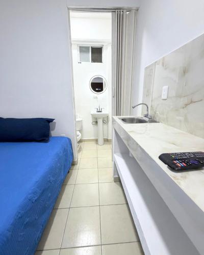 a bedroom with a blue bed and a sink at Hotel Posada Centro Atlacomulco Cuarto Barra in Atlacomulco de Fabela
