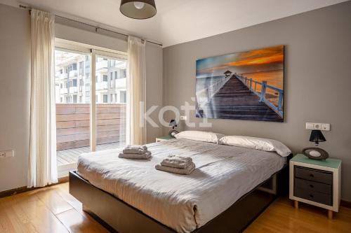 a bedroom with a bed with a painting on the wall at Terraza y Parking - Ático Capitán - Koti Rentals in Fuengirola
