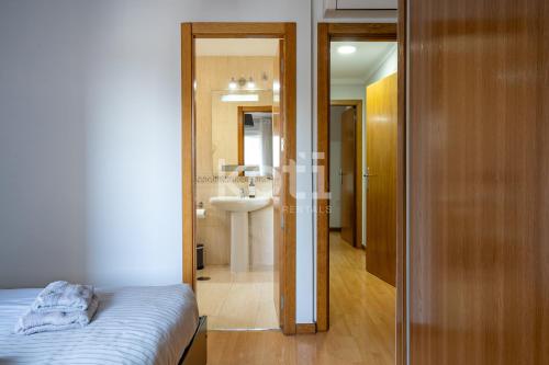 a bedroom with a bed and a bathroom with a sink at Terraza y Parking - Ático Capitán - Koti Rentals in Fuengirola