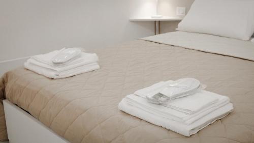 a bed with towels and glasses on top of it at Maison La Chicca in Molfetta