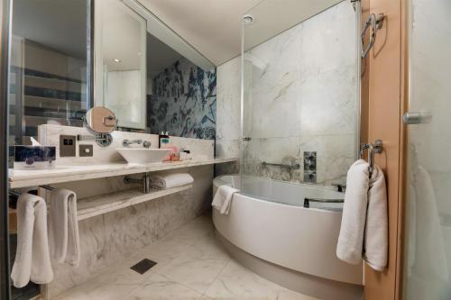 a bathroom with a tub and a sink at Media One Hotel Dubai, WorldHotels Crafted in Dubai