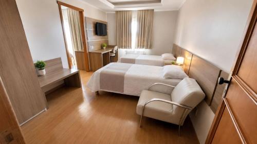 a hotel room with a bed and a chair at Hotel Prata Villaggio in Nova Prata