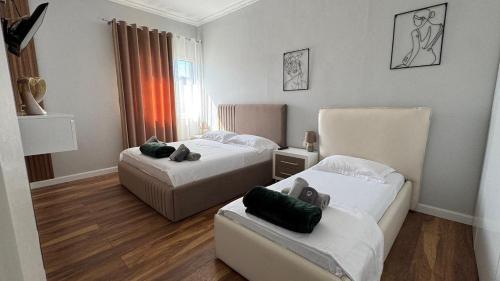 a hotel room with two beds and a couch at Agnesa Apartament in Gramsh