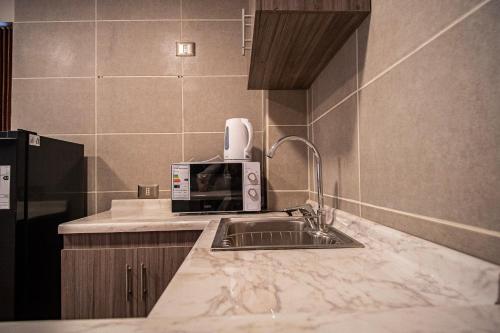 a kitchen with a sink and a microwave at Edificios Refugio in Nevados de Chillan