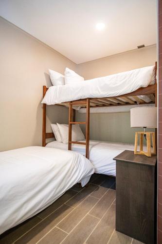 two bunk beds in a room with a lamp at Edificios Refugio in Nevados de Chillan