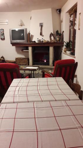 a room with a table with chairs and a television at Dulcamara in Pescasseroli