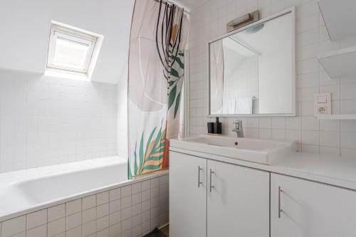 a white bathroom with a sink and a mirror at Brussels Guest House in Brussels