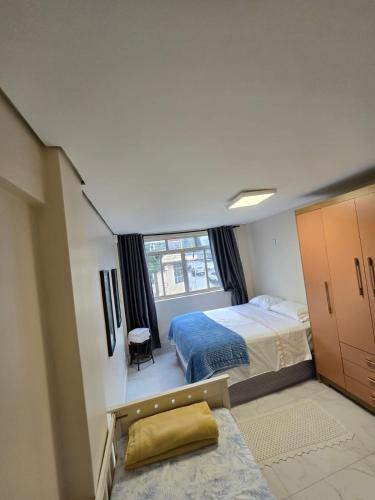 a small bedroom with a bed and a window at Apartamento Central in Cascavel