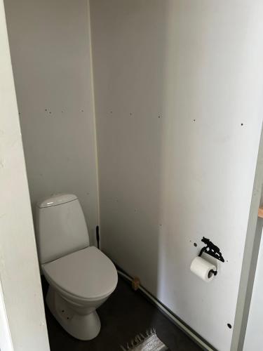 a bathroom with a toilet and a roll of toilet paper at Forest Outdoor 'Plan Torpet' Cabin in Södra Ström