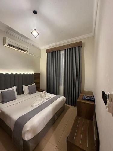 a bedroom with a large bed and a window at ركن النسيم للشقق الفندقية Rukn Al - Naseam Hotel Apartment in Jeddah