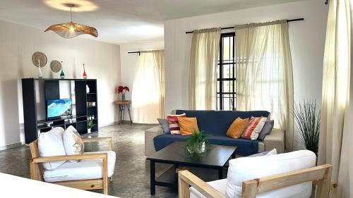a living room with a blue couch and a table at Casa Arena - 4 Pax, 5 min de la playa, con parking in Las Galeras