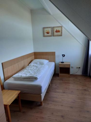a small bedroom with a bed and a table at Uut in Thuus in Buren