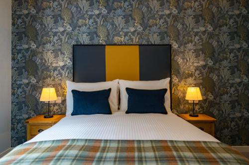 a bedroom with a large bed with two lamps at Kylesku Hotel & Kylesku House, by Highland Coast Hotels in Kylestrome