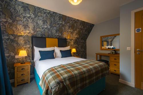 a bedroom with a large bed with a floral wallpaper at Kylesku Hotel & Kylesku House, by Highland Coast Hotels in Kylestrome