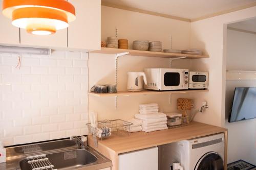a kitchen with a sink and a microwave at Guesthouse Life Field in Kurashiki