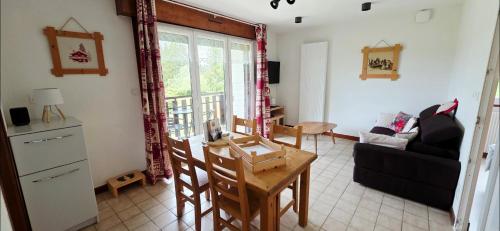 a living room with a couch and a table at MV Vacances in Les Rousses