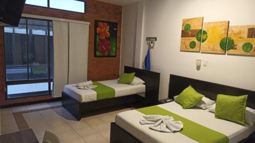 a hotel room with two beds and a window at Hotel Chicala salgar in Puerto Salgar