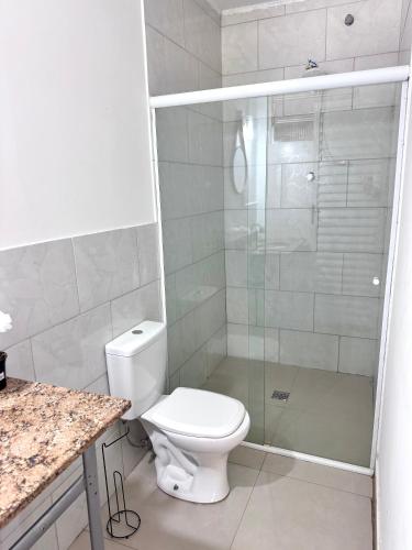 a bathroom with a toilet and a glass shower at quarto suíte privativo em campinas para até 4 pessoas in Campinas